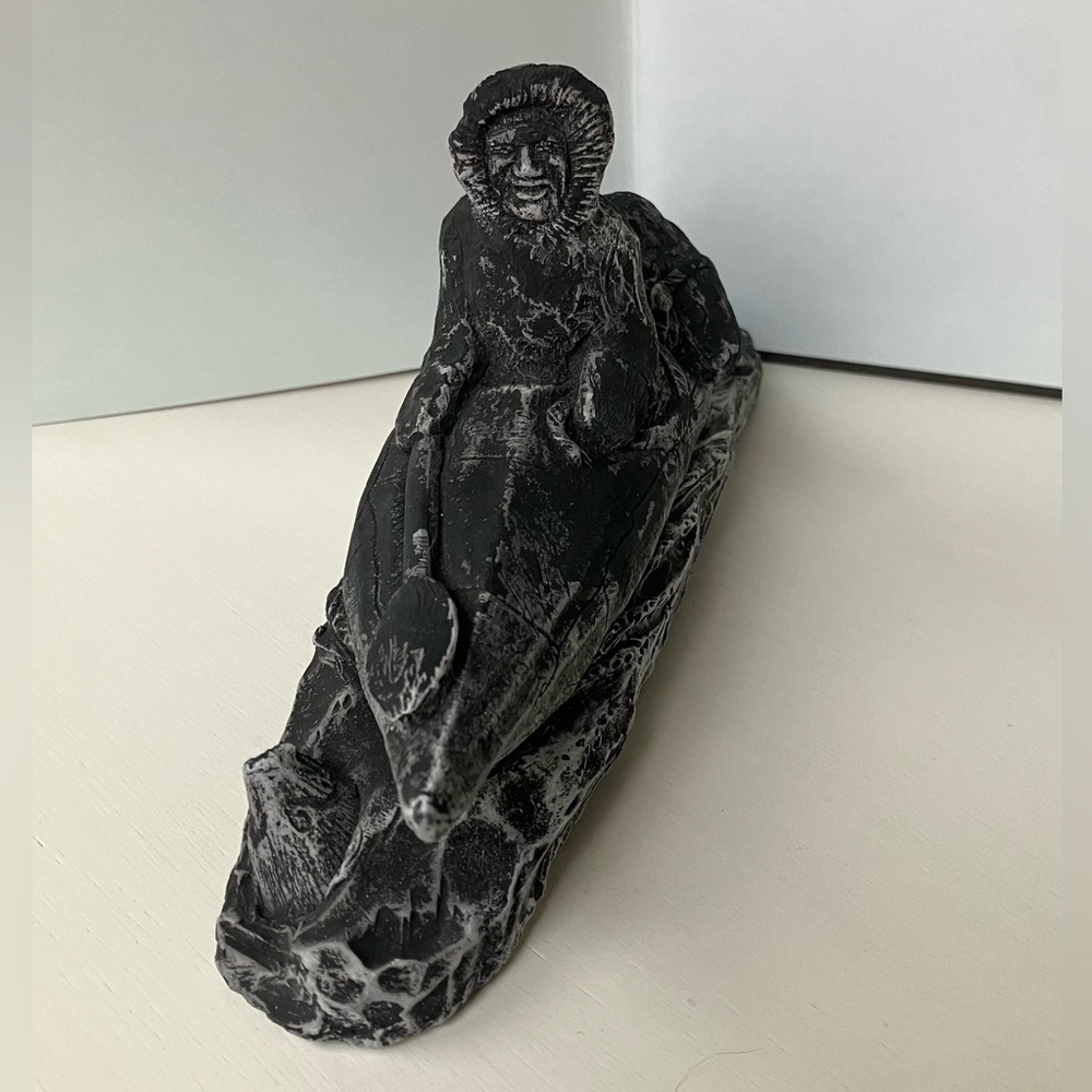 Inuit-style sculpture, depicting a person in a kayak or canoe with a seal